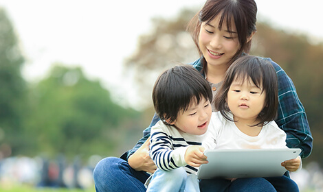 公園でタブレットを使う親子